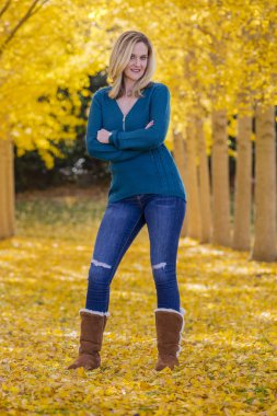 Güzel sarışın Model sarı yapraklar bir alana poz