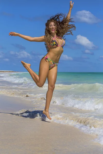 Spansktalande brunett modell kör på stranden — Stockfoto