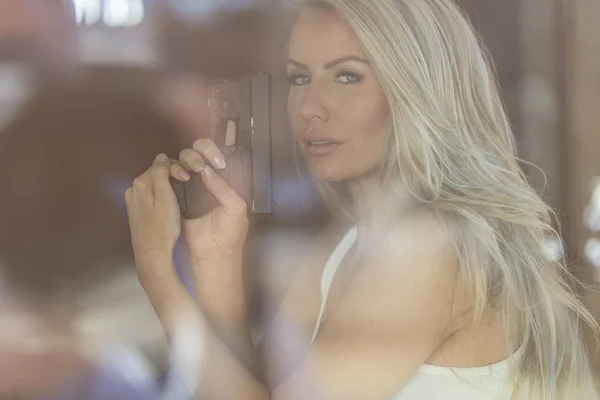 Gorgeous blond modell skydda sig själv med en Pistol — Stockfoto