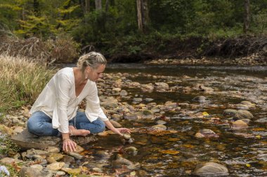 Güzel bir sarışın manken parkta sonbahar gününün tadını çıkarıyor.