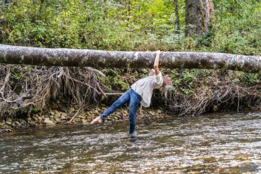 Güzel bir sarışın manken parkta sonbahar gününün tadını çıkarıyor.