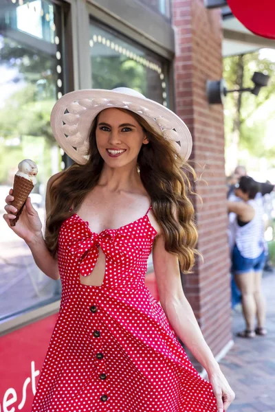 Preciosa morena modelo comiendo helado mientras posando al aire libre — Foto de Stock