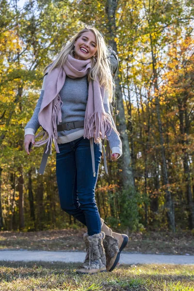 Una bella modella bionda gode di una giornata d'autunno all'aperto al parco — Foto Stock