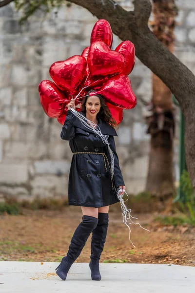 Güzel İspanyol Esmer Modeli Sevgililer Günü 'nü Bir düzine Kırmızı Kalp Balonuyla Kutluyor — Stok fotoğraf