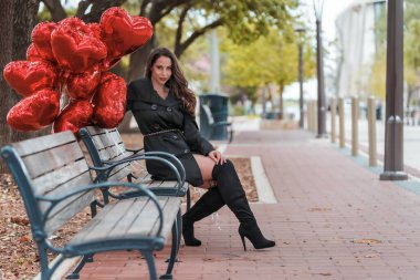 Sevgililer Günü için bir düzine balonu olan güzel bir esmer manken.