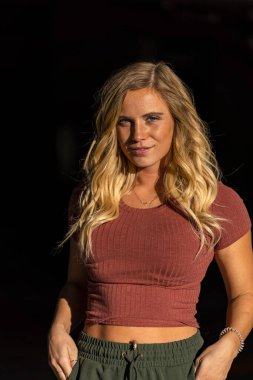 Muhteşem sarışın bir model, bir sonbahar günü park yerinde poz verir.