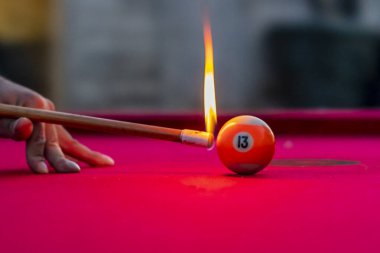 Açık bir ortamda dışarıda otururken bilardo topları ateşte fotoğraflanır.
