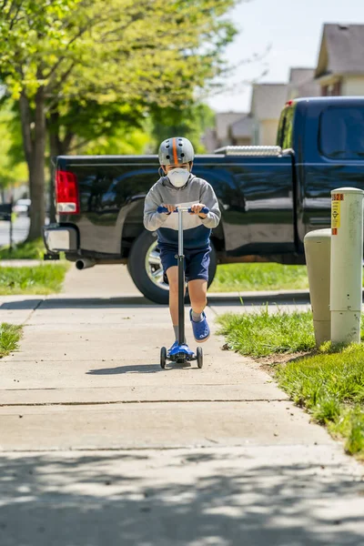 Child Rides His Scooter Sidewalk Suburban Environment Using Protective Mask — Stock Photo, Image
