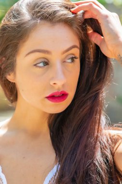 Muhteşem bir esmer model, açık havada bir bahar gününün tadını çıkarıyor. 