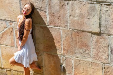 Muhteşem bir esmer model, açık havada bir bahar gününün tadını çıkarıyor. 