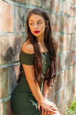 Muhteşem bir esmer model, açık havada bir bahar gününün tadını çıkarıyor. 