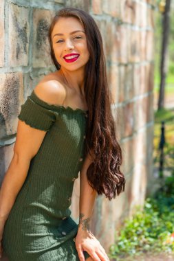 Muhteşem bir esmer model, açık havada bir bahar gününün tadını çıkarıyor. 