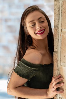 Muhteşem bir esmer model, açık havada bir bahar gününün tadını çıkarıyor. 