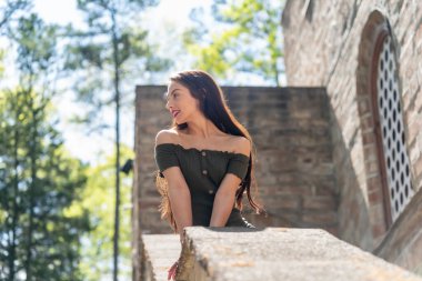 Muhteşem bir esmer model, açık havada bir bahar gününün tadını çıkarıyor. 