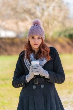 Sarışın bir manken en sevdiği içeceği içerken kış günlerini dışarıda geçirir.