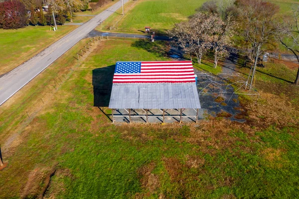 アメリカの農場近くの納屋にアメリカ国旗が描かれた田舎道 — ストック写真