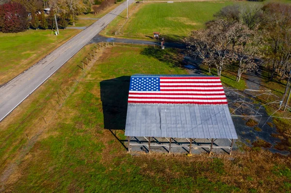 アメリカの農場近くの納屋にアメリカ国旗が描かれた田舎道 — ストック写真