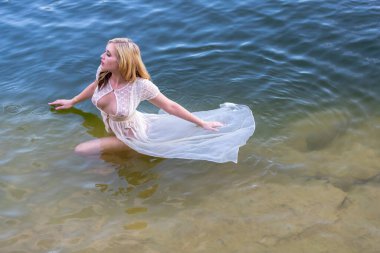 Muhteşem bir sarışın manken, yaz günlerinde gölün tadını çıkarıyor.