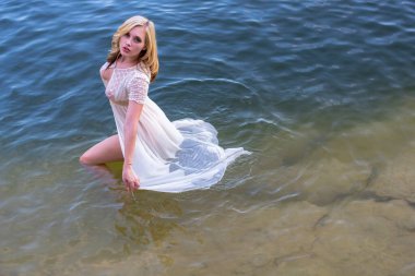 Muhteşem bir sarışın manken, yaz günlerinde gölün tadını çıkarıyor.