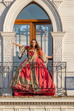 Muhteşem bir İspanyol esmer model ev ortamında geleneksel Meksika kıyafetleriyle poz veriyor.