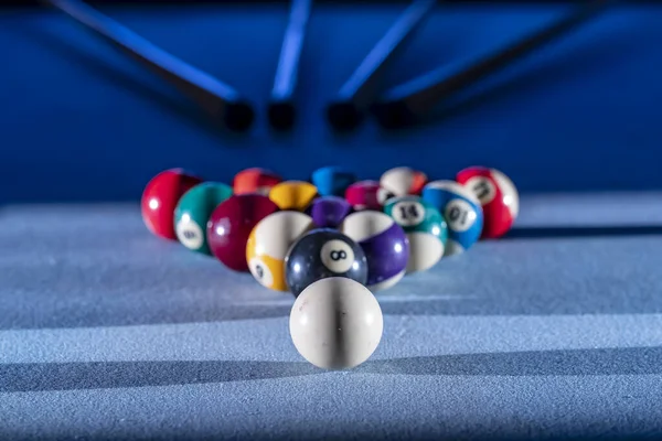 A racked up triangle of billiard balls on the table, ready for a game of pool