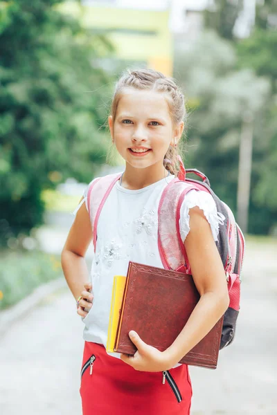 Écolière avec un sac à dos et un livre dans les mains — Photo