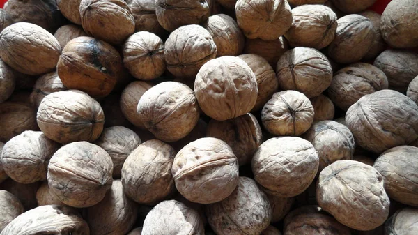 Heap of walnuts with peel. A large number of untreated walnut. — Stock Photo, Image