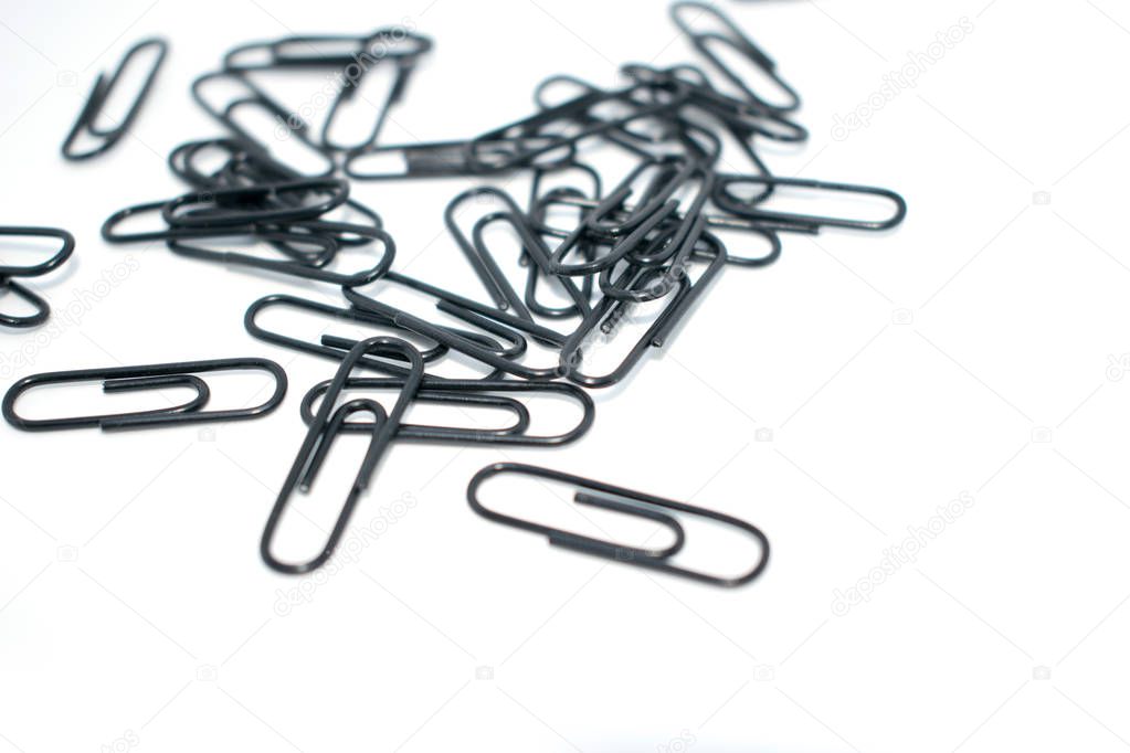 Clip for office accessories. Stationery. Black clips in a chaotic order.