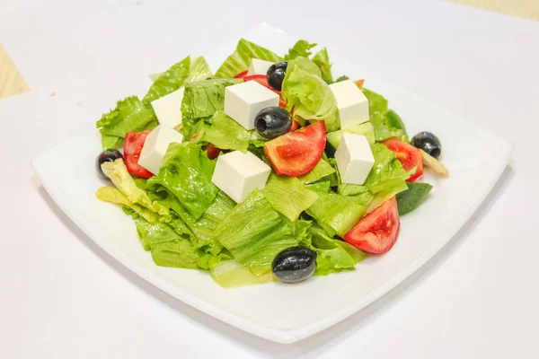 Beyaz Tabakta Domates Zeytin Peynir Otlu Yunan Salatası Fotoğrafı — Stok fotoğraf