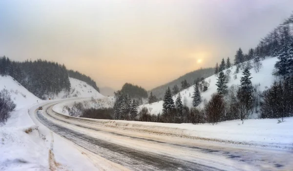Vinter bergsväg i den uppgående solens strålar. Sakhalin. Stockbild