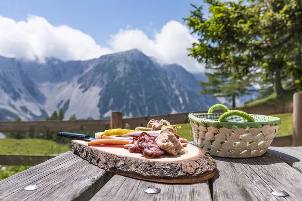 Brettljause en la mesa de madera con vistas a la cordillera Karawanks — Foto de Stock