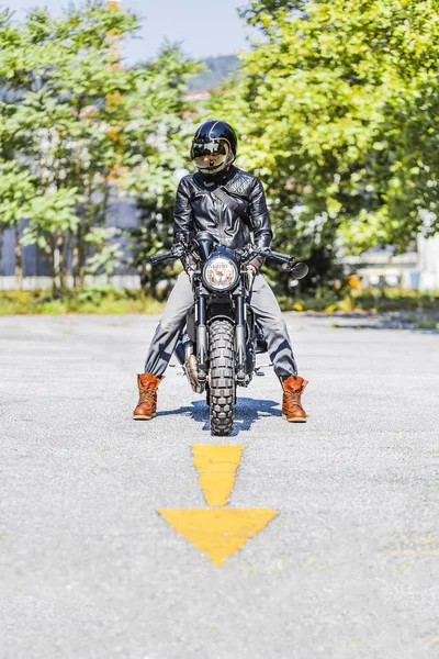 Cool looking motorcycle rider on custom made scrambler style caf — Stock Photo, Image