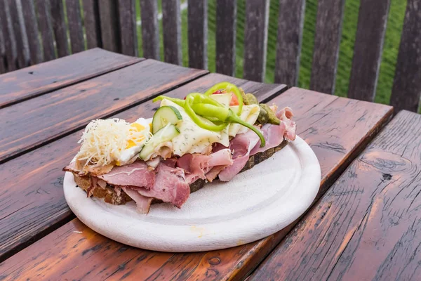 Traditionella bröd med massor av kallskuret på träbord på sout — Stockfoto