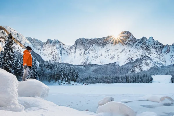Dağı'na bakarak donmuş göl üzerinde turuncu ceketli adamı — Stok fotoğraf