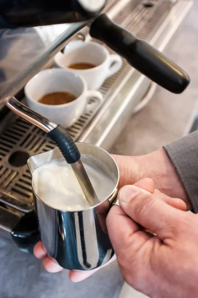 Ångande och skumma mjölk i tumlaren för cappuccino eller latte — Stockfoto