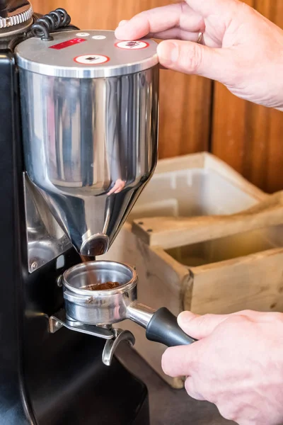 Бариста шлифовка кофейных зерен с молотилкой для приготовления кофе эспрессо — стоковое фото