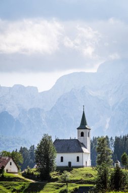 Church Cerkev Sveti Duh with mountain range Kamnik Savinja Alps clipart