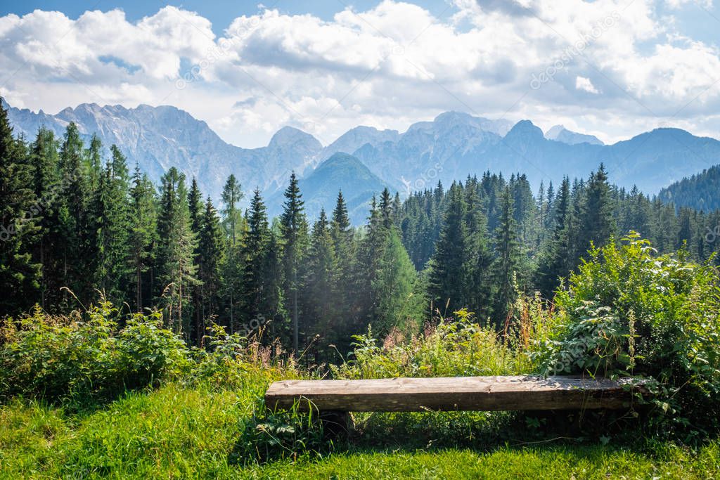 Wooden bench in front of Kamnik Savinja Alps in Slovenia
