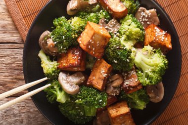 Fry tofu, brokoli, mantar ve susam yakın çekim bir p ilave edin.