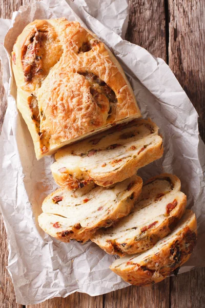 Delicious bread with cheese, bacon and dried tomatoes close-up. — Stock Photo, Image