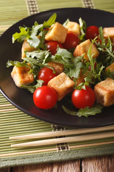 Smażone tofu z pomidorami i świeżą rukolą zbliżenie na talerzu. — Zdjęcie stockowe