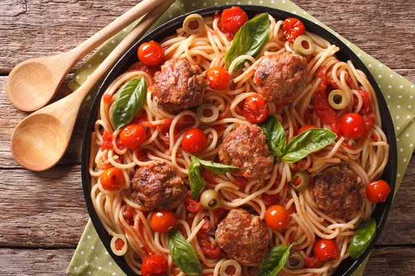 Pasta spaghetti with meatballs, olives and tomatoes closeup. Hor