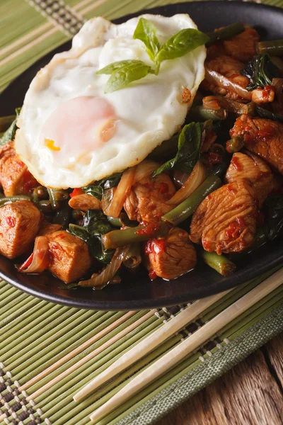 Poulet thaïlandais au basilic, haricots verts et un œuf frit sur une assiette — Photo