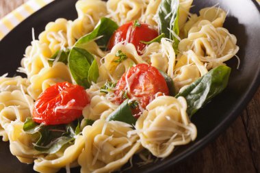 Ispanak, domates ve parmesan yakın çekim ile İtalyan tortellini.