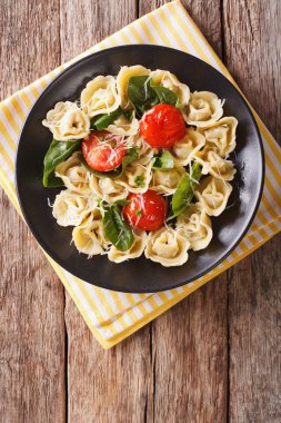 Bir tabak ıspanak ve parmesan ile taze pişmiş tortellini. 