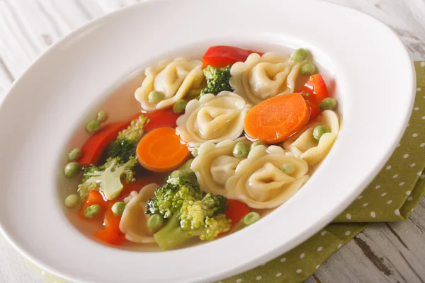 Sıcak tortellini çorba, brokoli, bezelye, havuç ve biber kapatın