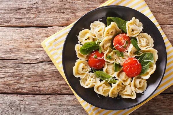 Tortellini fraîchement cuit aux épinards et au parmesan sur une assiette . — Photo