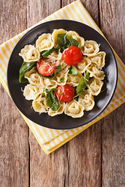 Bir tabak ıspanak ve parmesan ile taze pişmiş tortellini. 