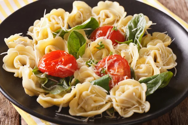 Итальянская кухня: тортеллини со шпинатом, помидоры крупным планом — стоковое фото