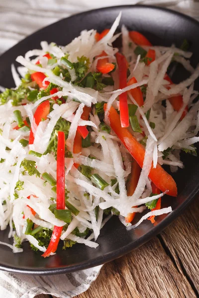 Fresh salad of daikon with pepper and herbs closeup. Vertical — Stock Photo, Image